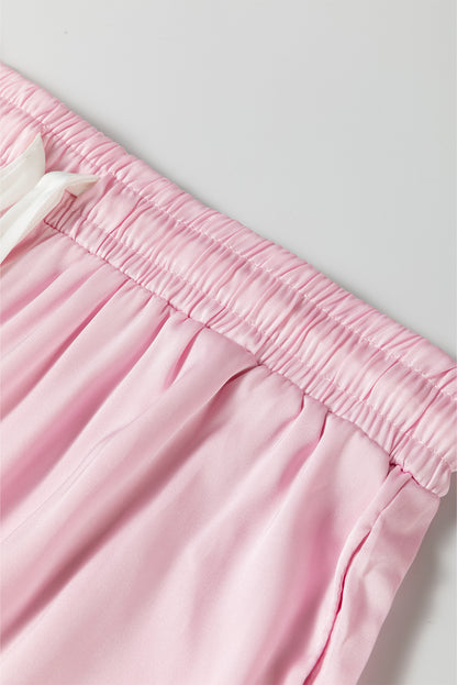 Elegant light pink satin lounge set with knot accent and ruffled pants