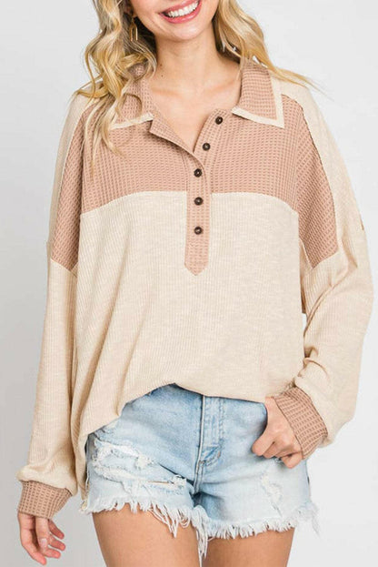 Chic color block half-button blouse with waffle-knit texture and sheer design.