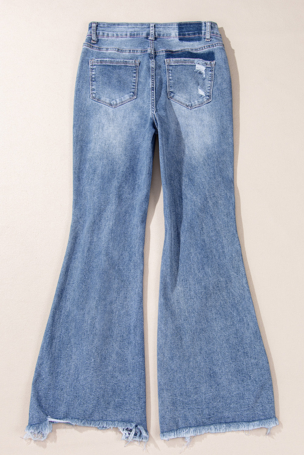 Dusk blue high-waisted flared jeans with distressed hem and ripped details