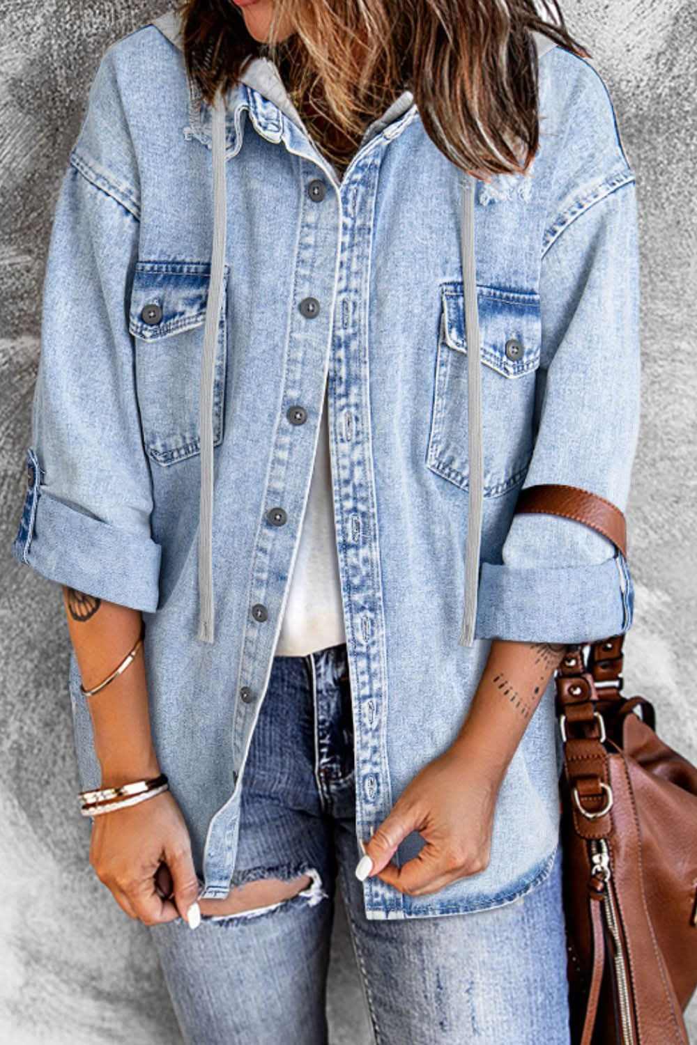 Distressed hooded denim jacket with button-up front and pockets.