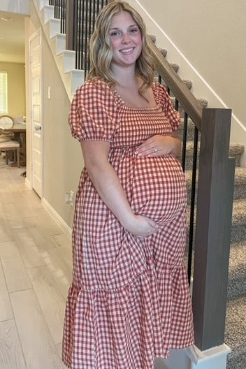 Lifestyle shot of the PinkBlush Rust Gingham Smocked Maternity Midi Dress, demonstrating its versatility and comfortable wear