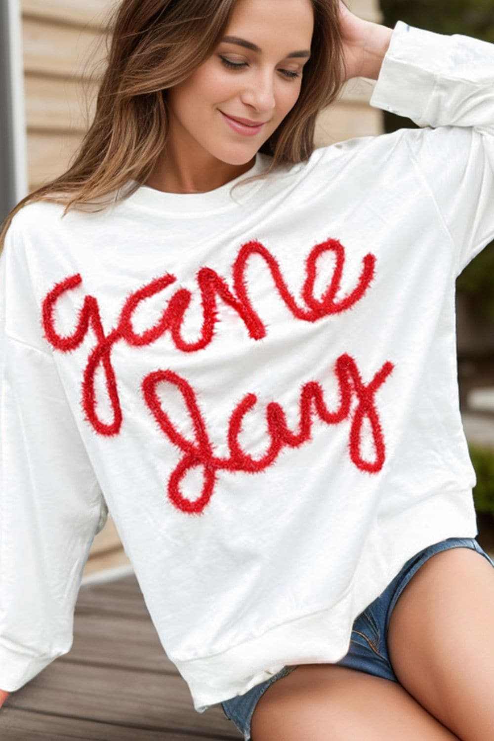 Round neck long sleeve sweatshirt with red script design.