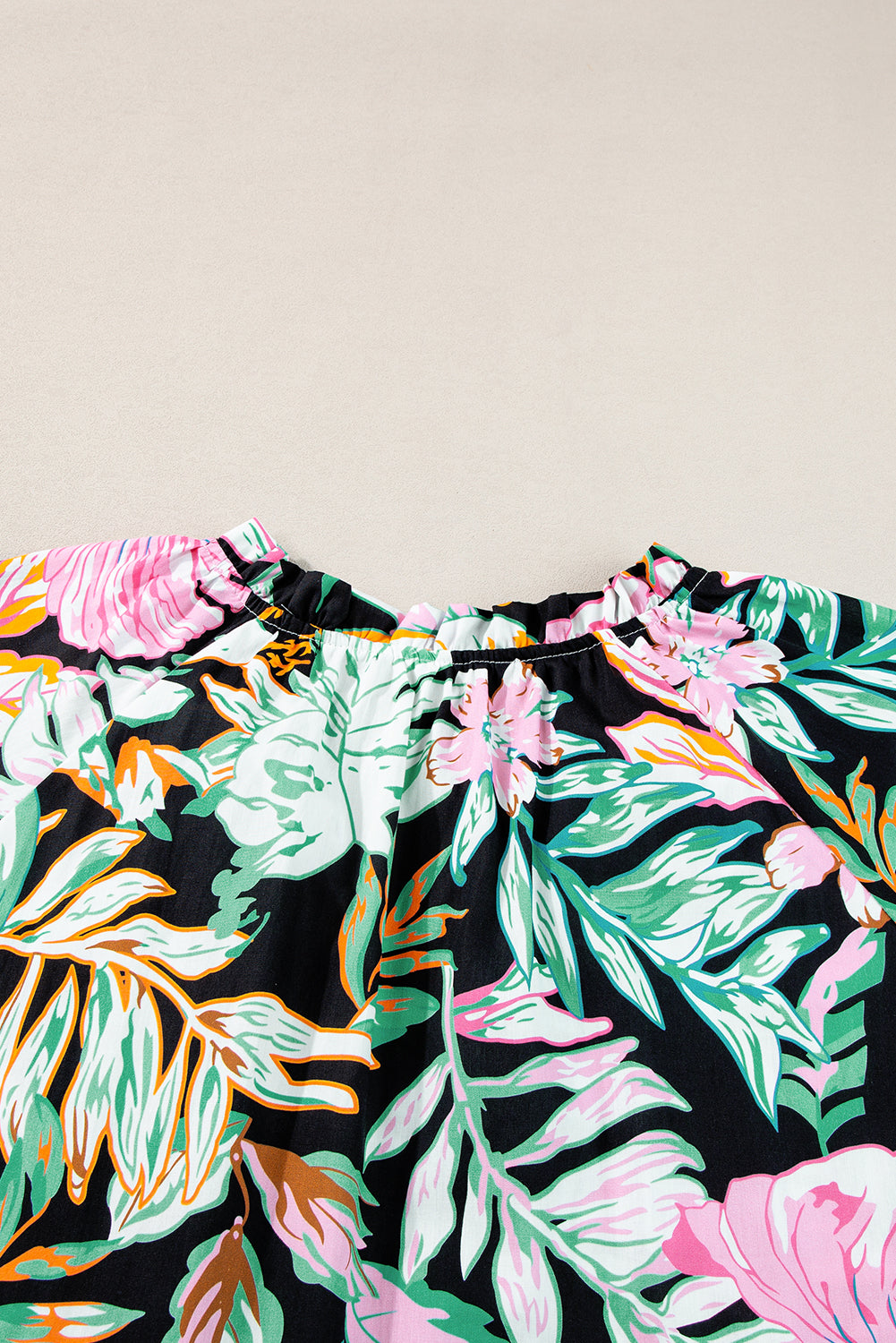 Elegant black tropical print blouse with ruffled sleeves and flowy design