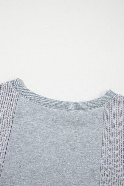 Chic light grey waffle patchwork pullover with raw hem details