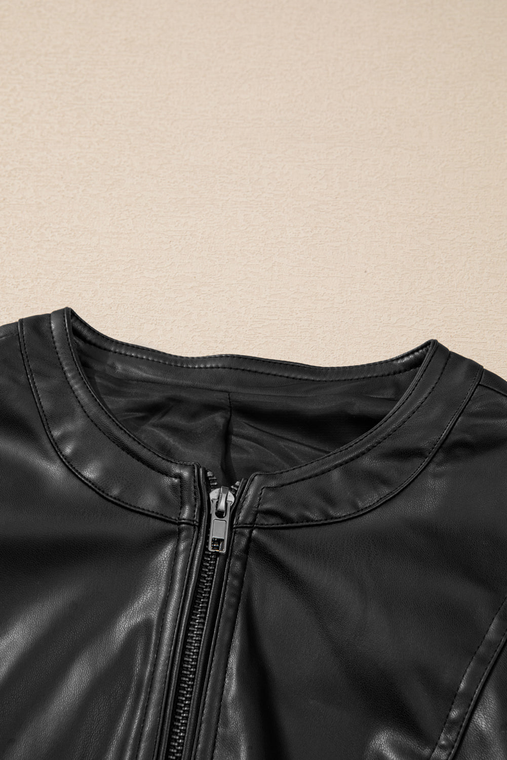 Sleek black faux leather bomber jacket with trendy zipper details