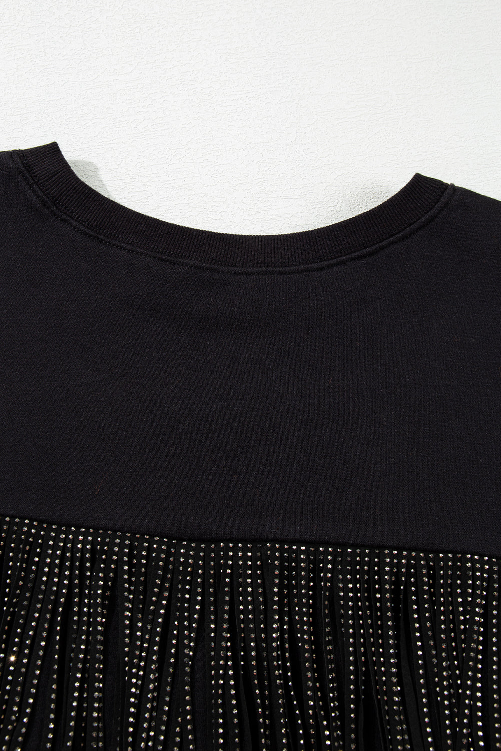 Sparkle on game day with a black cropped rugby sweatshirt featuring tassels and sequins