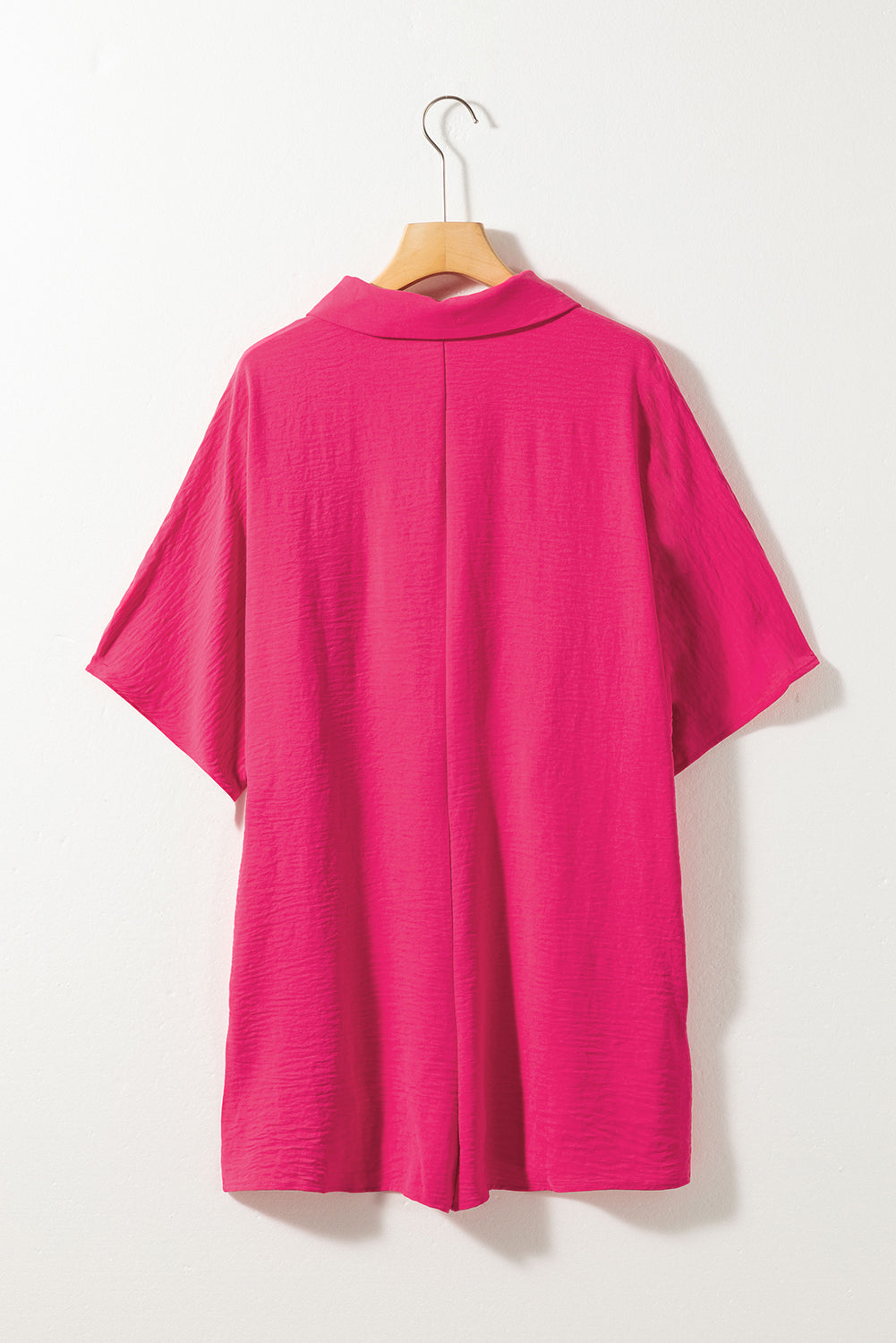 Vibrant pink oversized half-button collared romper for effortless style