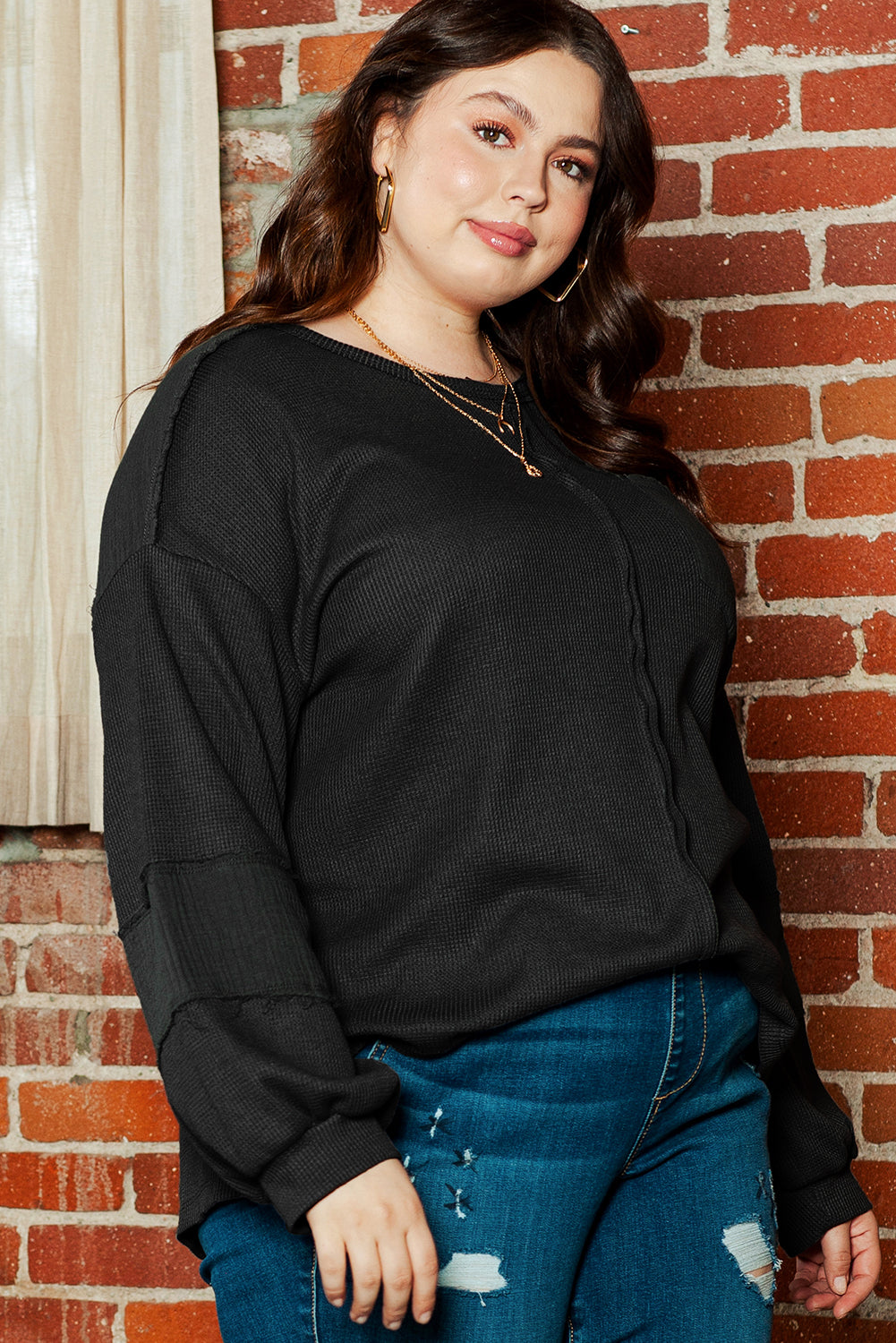 Chic black crinkle patchwork top in plus sizes with exposed seams