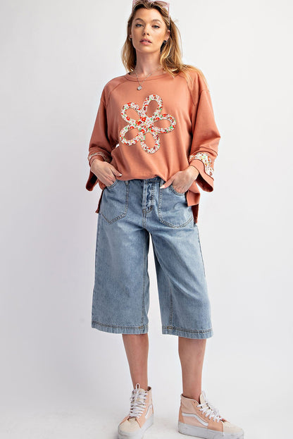 Floral graphic wide-sleeve top with exposed seam detail in grapefruit orange