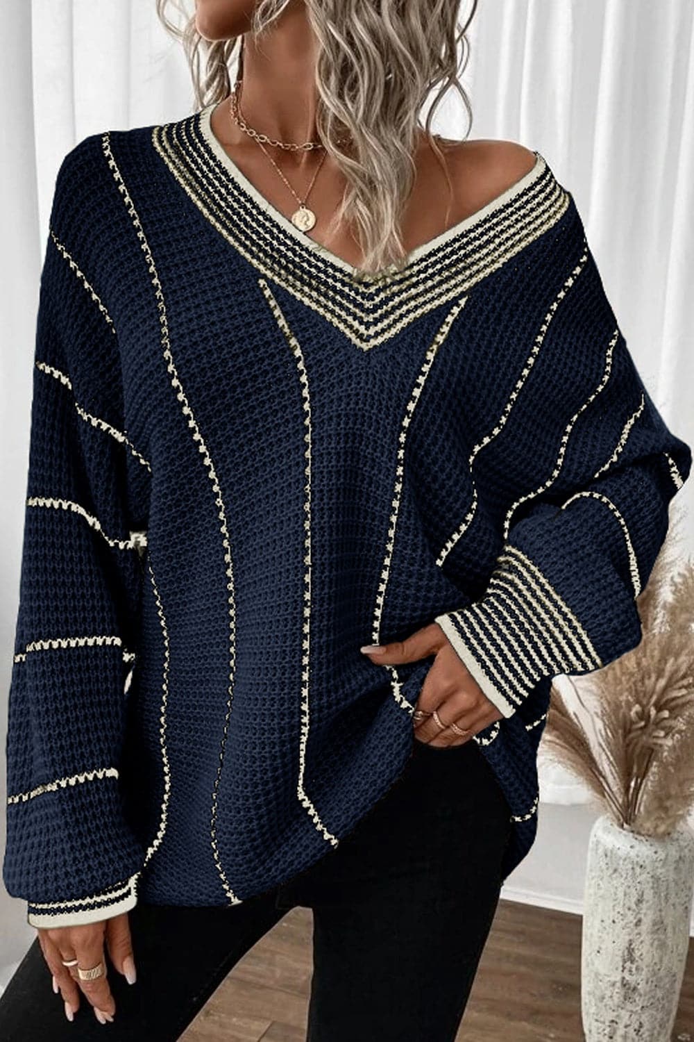 Vibrant striped v-neck sweater in navy with white accents, slightly stretchy, 100% acrylic.