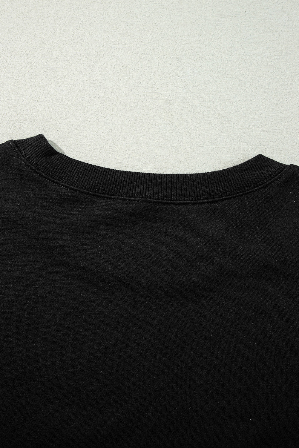 Chic black drop shoulder sweatshirt with exposed seams and side slits