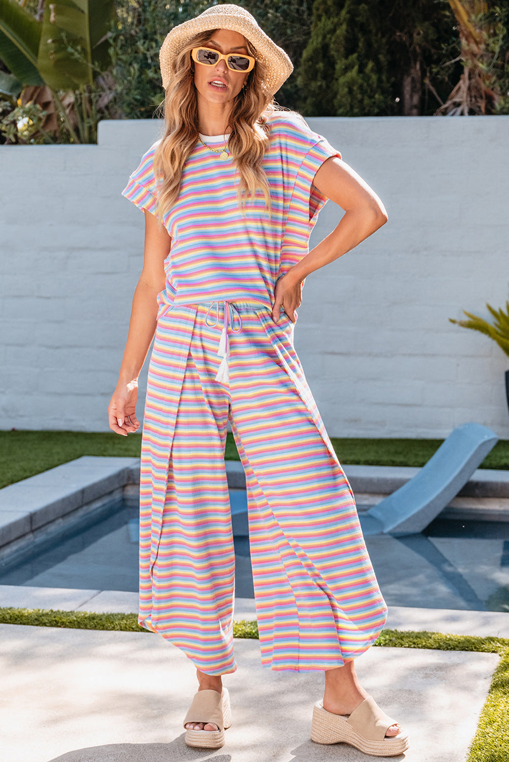 Chic pink striped rainbow tee and tasseled wide leg pants ensemble