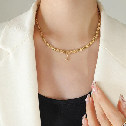 Brass inlaid zircon letter pendant necklace on model, 18K gold-plated elegance.