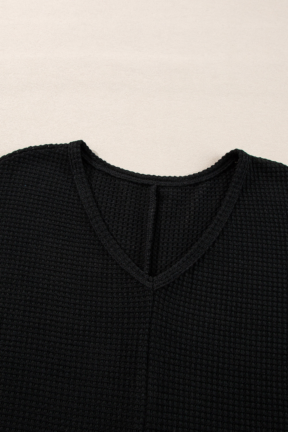 Chic black waffle knit V-neck top with side slits and loose fit