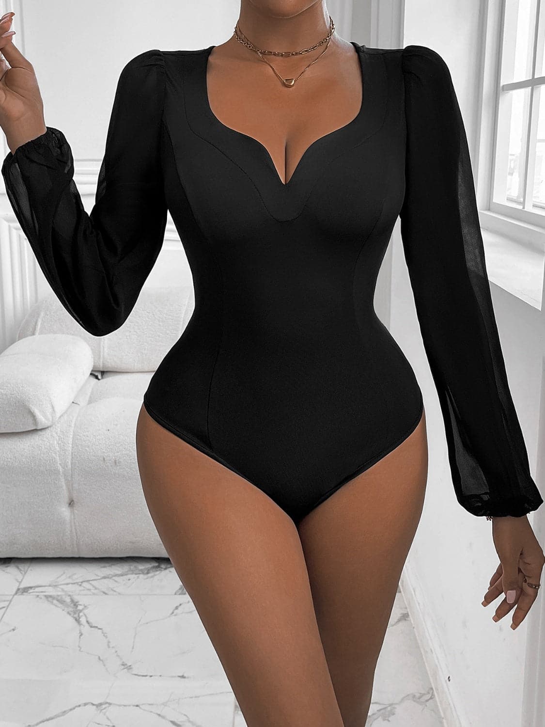 Chic long sleeve bodysuit, sheer and stretchy design in black.