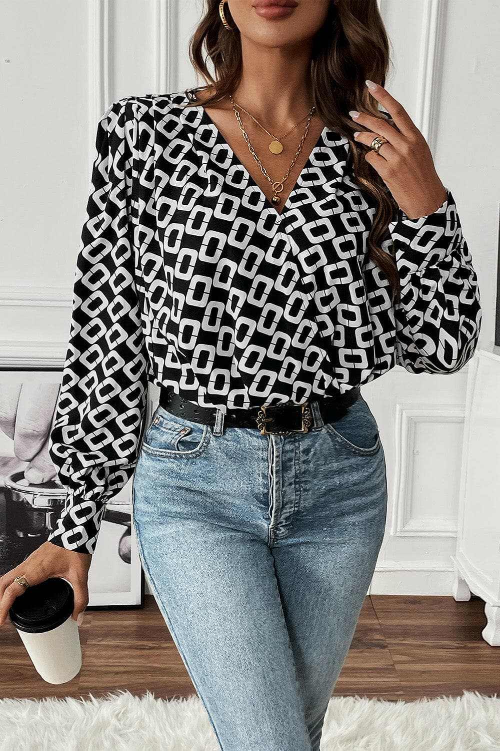 Geometric V-neck long sleeve blouse with a chic pattern, paired with jeans.