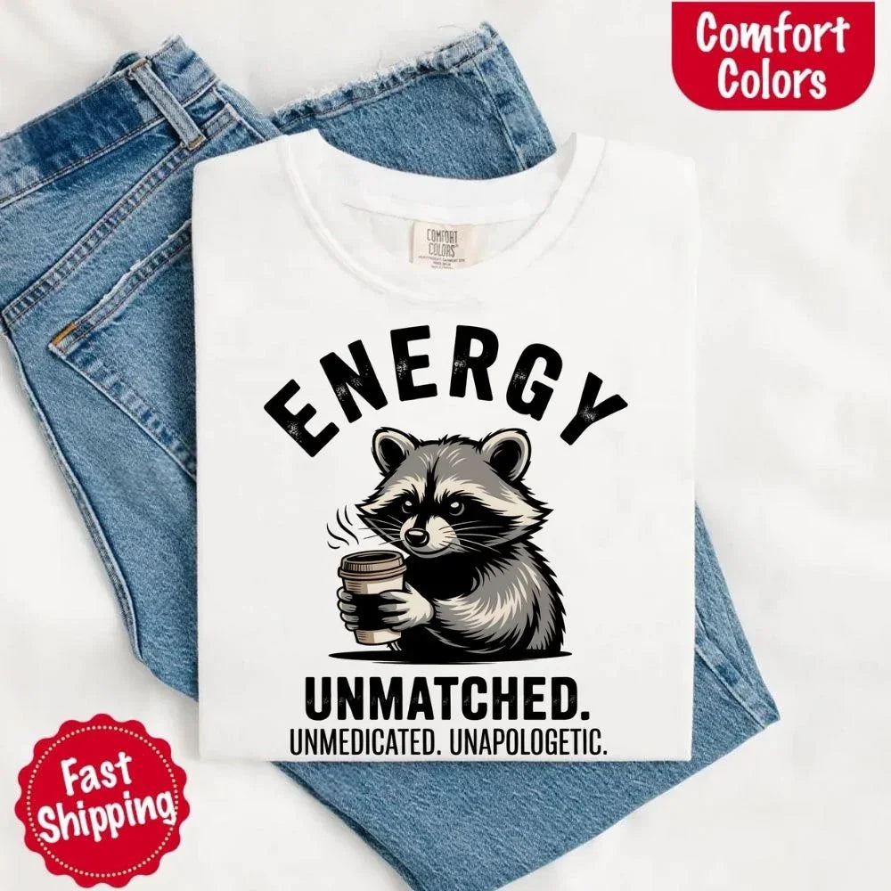 Adorb Custom Tees funny raccoon coffee t-shirt paired with a mug, perfect for everyday wear by coffee lovers.