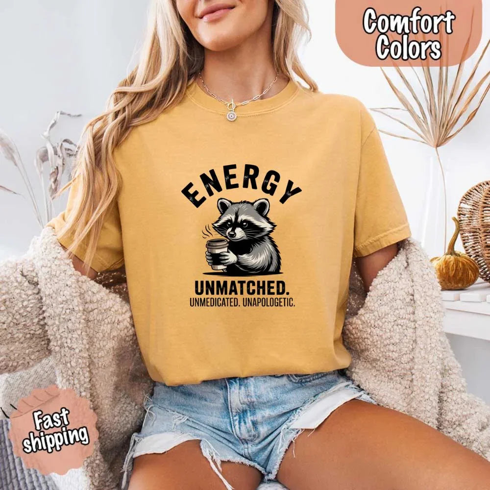 Adorb Custom Tees graphic tee featuring the "Energy Unmatched" raccoon coffee design, folded neatly.