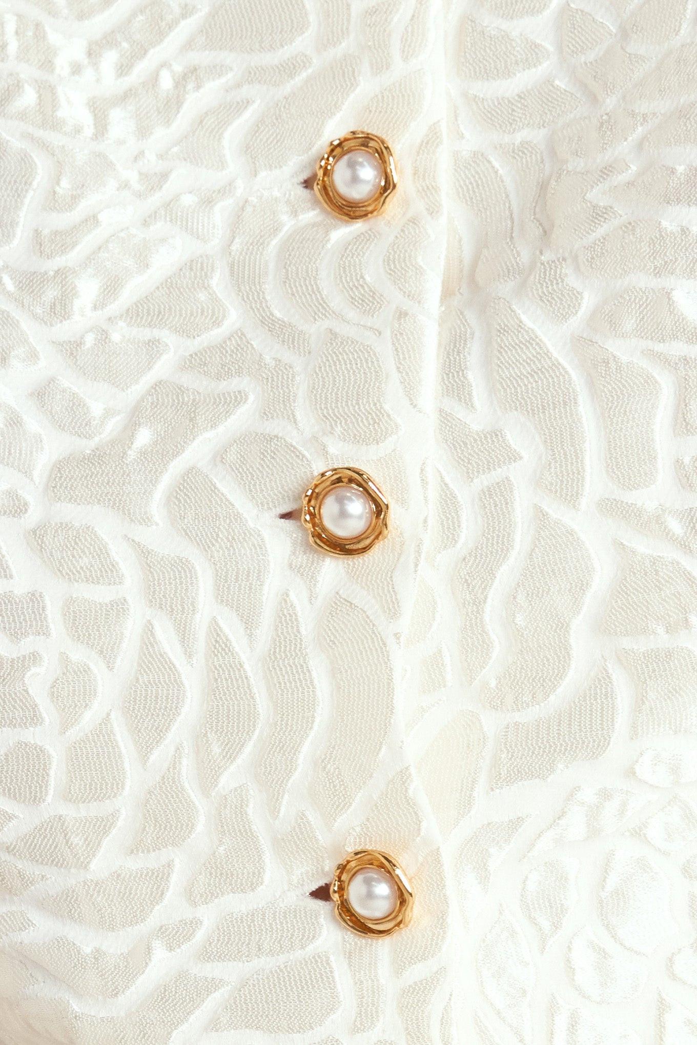 Detail of the Flying Tomato Rosé Texture Woven Top, showcasing its refined hem and the premium quality of the woven fabric.