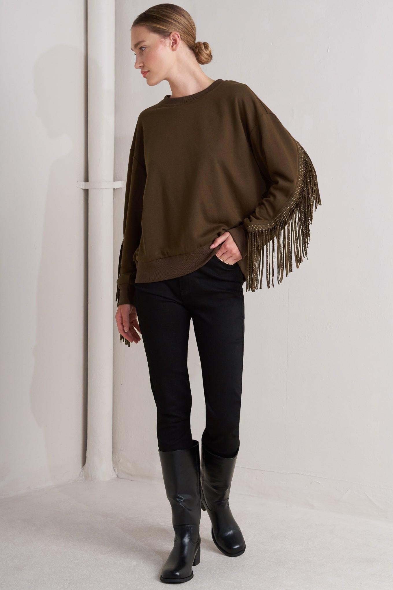 Detail of the Flying Tomato Fringe City Pullover Knit Top, focusing on the stylish hemline and relaxed sleeve design.