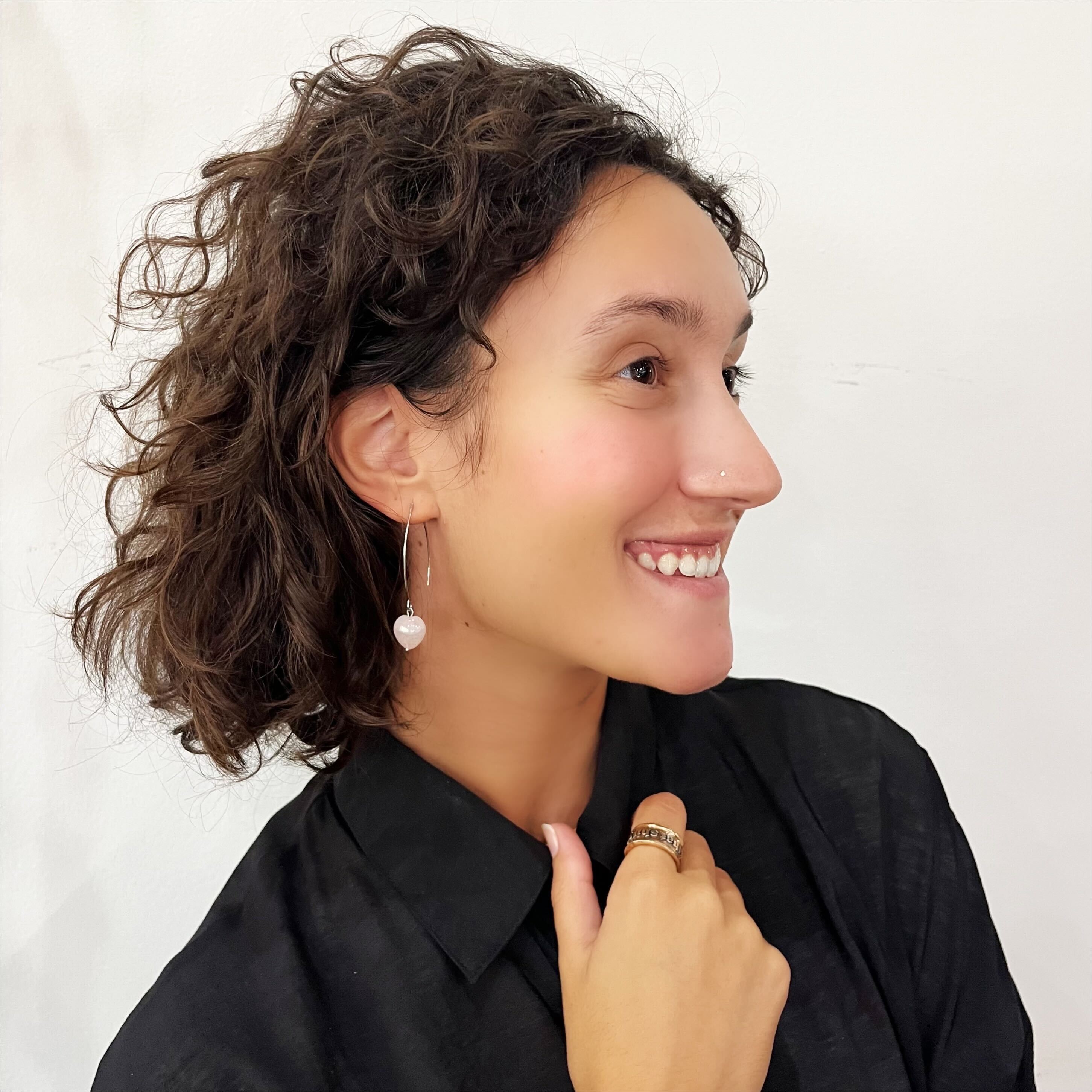 Katia Designs Small Stone Drop Earrings displayed on a wooden vanity next to a small plant, perfect for a minimalist aesthetic.