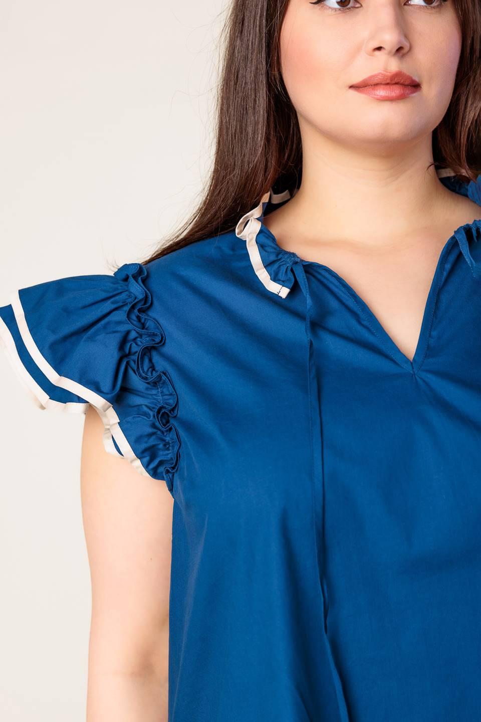 Close-up of the Flying Tomato brand tag on THE TIME IS RIGHT WOVEN TOP, signifying authentic, quality apparel.