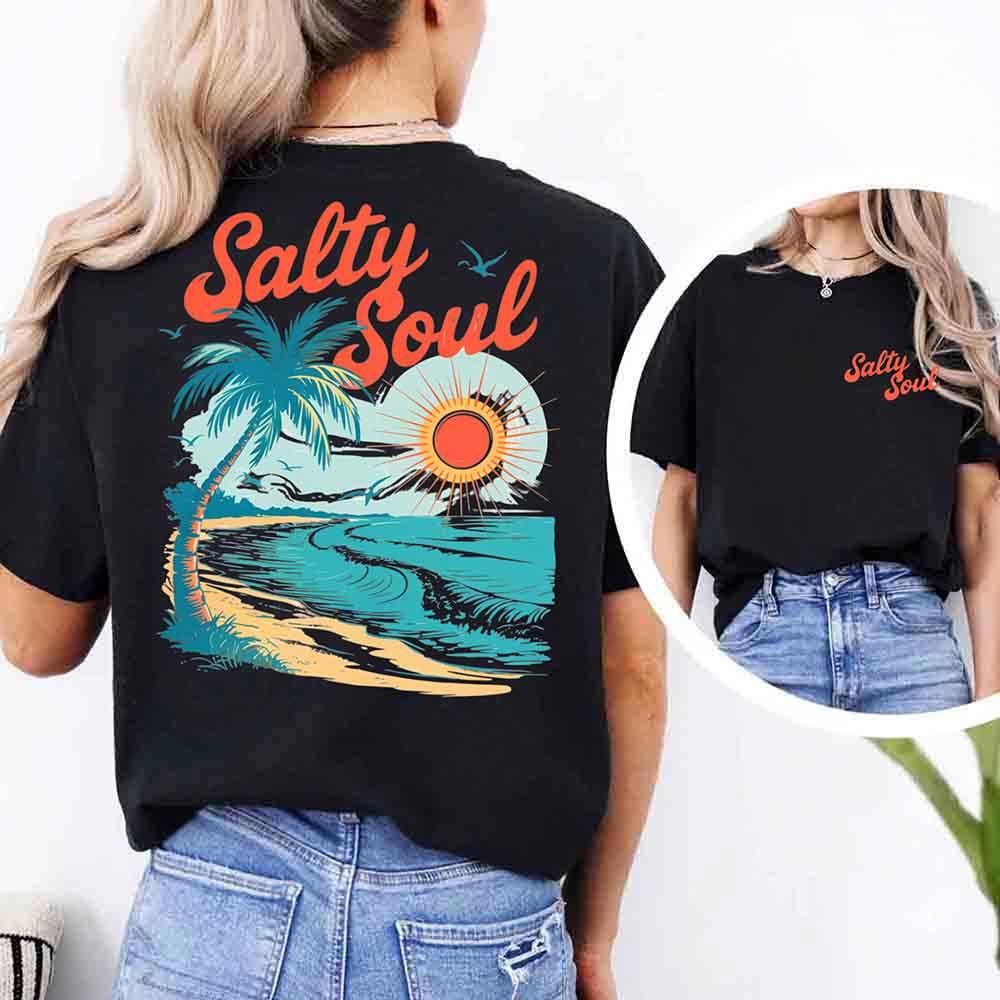 Woman enjoying the beach in her Adorb Custom Tees Salty Soul Comfort Colors Tee, perfect for a relaxed summer day.