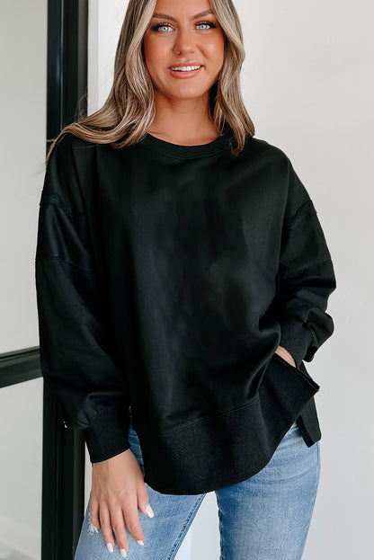 Chic black drop shoulder sweatshirt with exposed seams and side slits