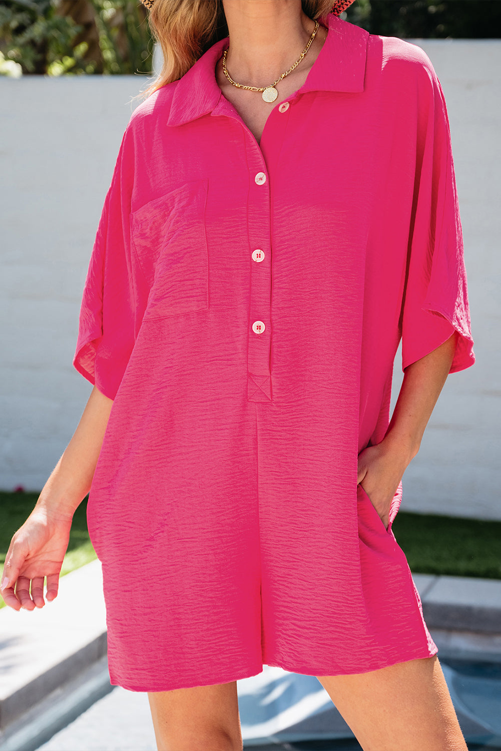 Vibrant pink oversized half-button collared romper for effortless style