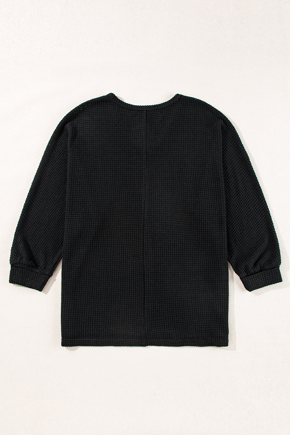 Chic black waffle knit V-neck top with side slits and loose fit