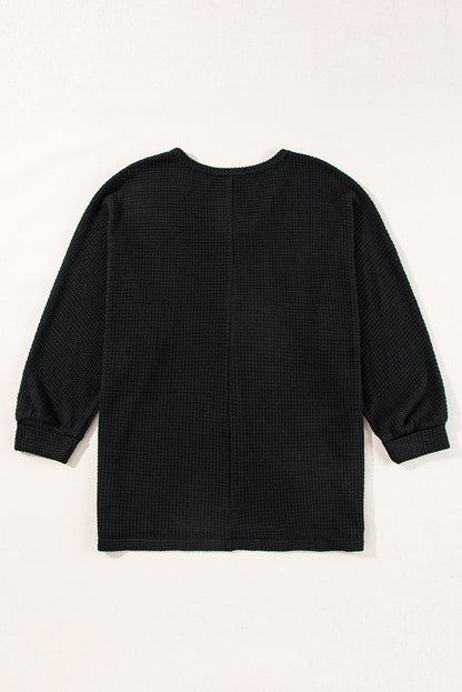 Chic black waffle knit V-neck top with side slits and loose fit