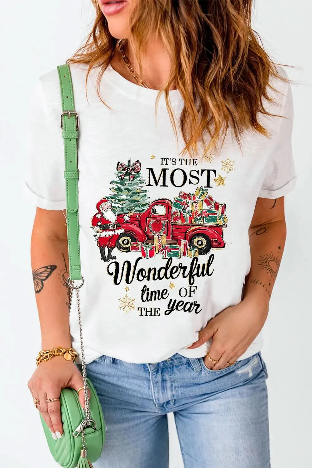 Graphic round neck short sleeve t-shirt with festive design, woman in jeans holding a green bag.