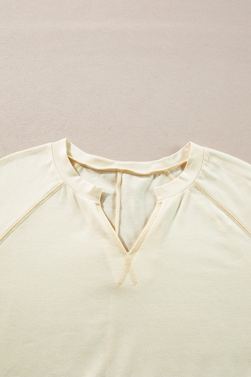 Chic apricot long sleeve top with notched neckline and exposed stitching