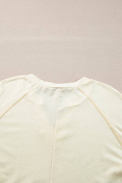 Chic apricot long sleeve top with notched neckline and exposed stitching