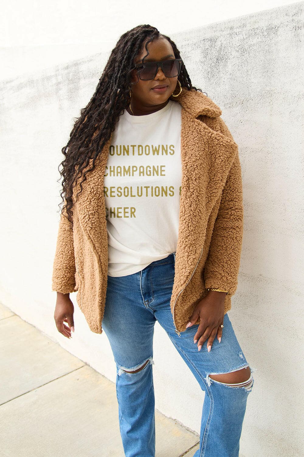 Woman wearing Simply Love Joyful Resolutions tee, paired with a cozy brown coat and ripped jeans, showcasing casual and versatile style.