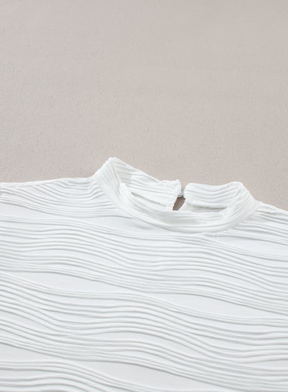 Elegant white textured mock neck top with cap sleeves