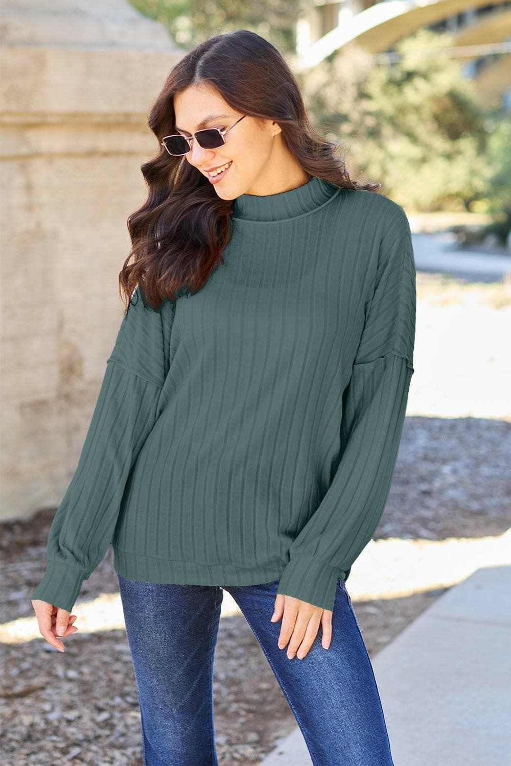 Sleek ribbed mock neck knit top with exposed seams for chic style and comfort.