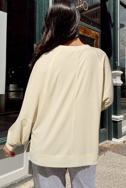 Chic apricot long sleeve top with notched neckline and exposed stitching