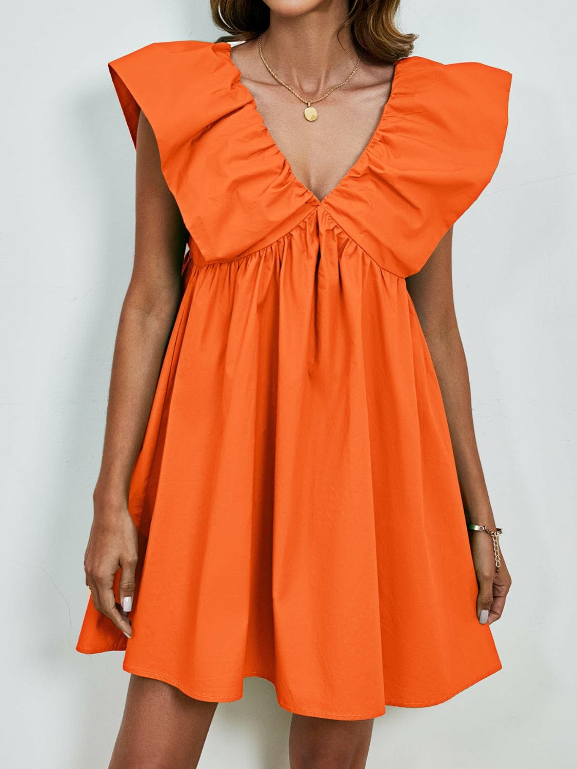 V-neck cap sleeve mini dress in vibrant orange with ruffled detailing.