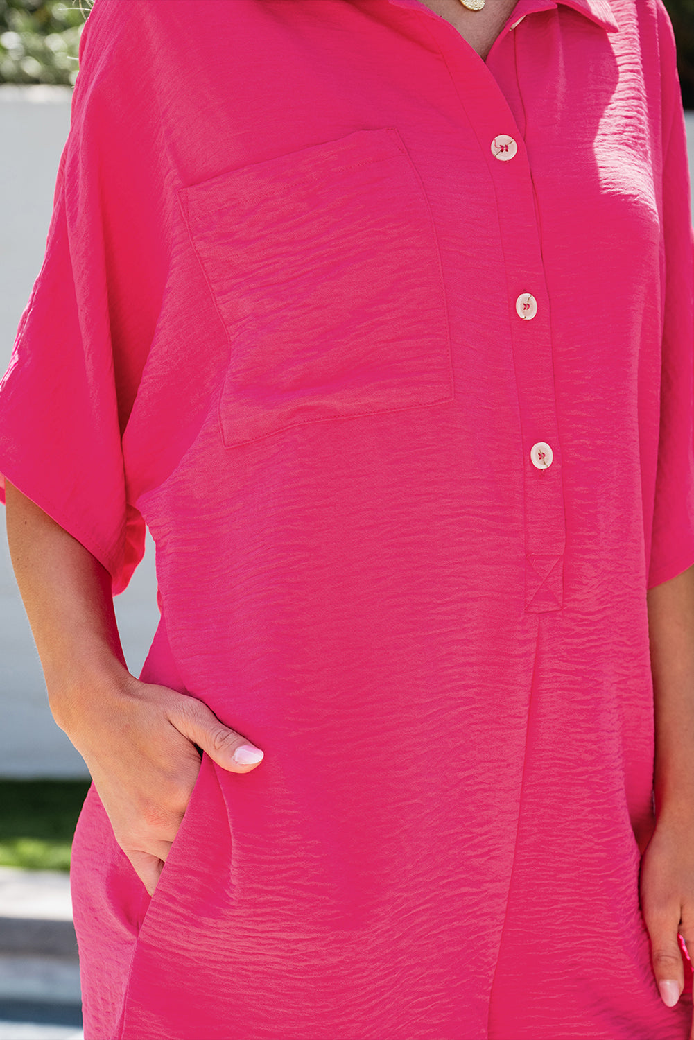 Vibrant pink oversized half-button collared romper for effortless style