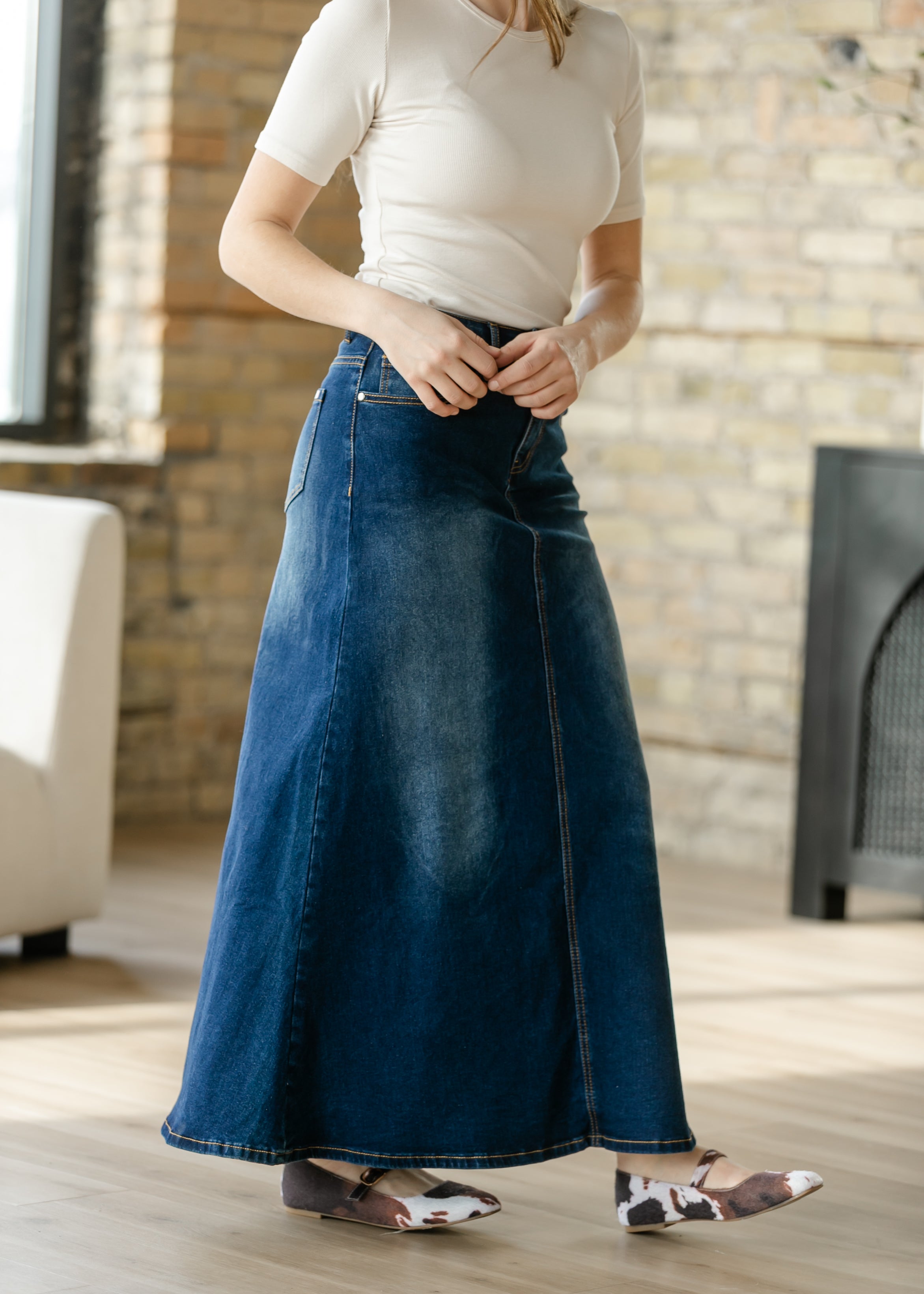 Close-up of the classic button closure and practical pockets on the Inherit Co. Bethany Dark Wash A-line Denim Skirt.