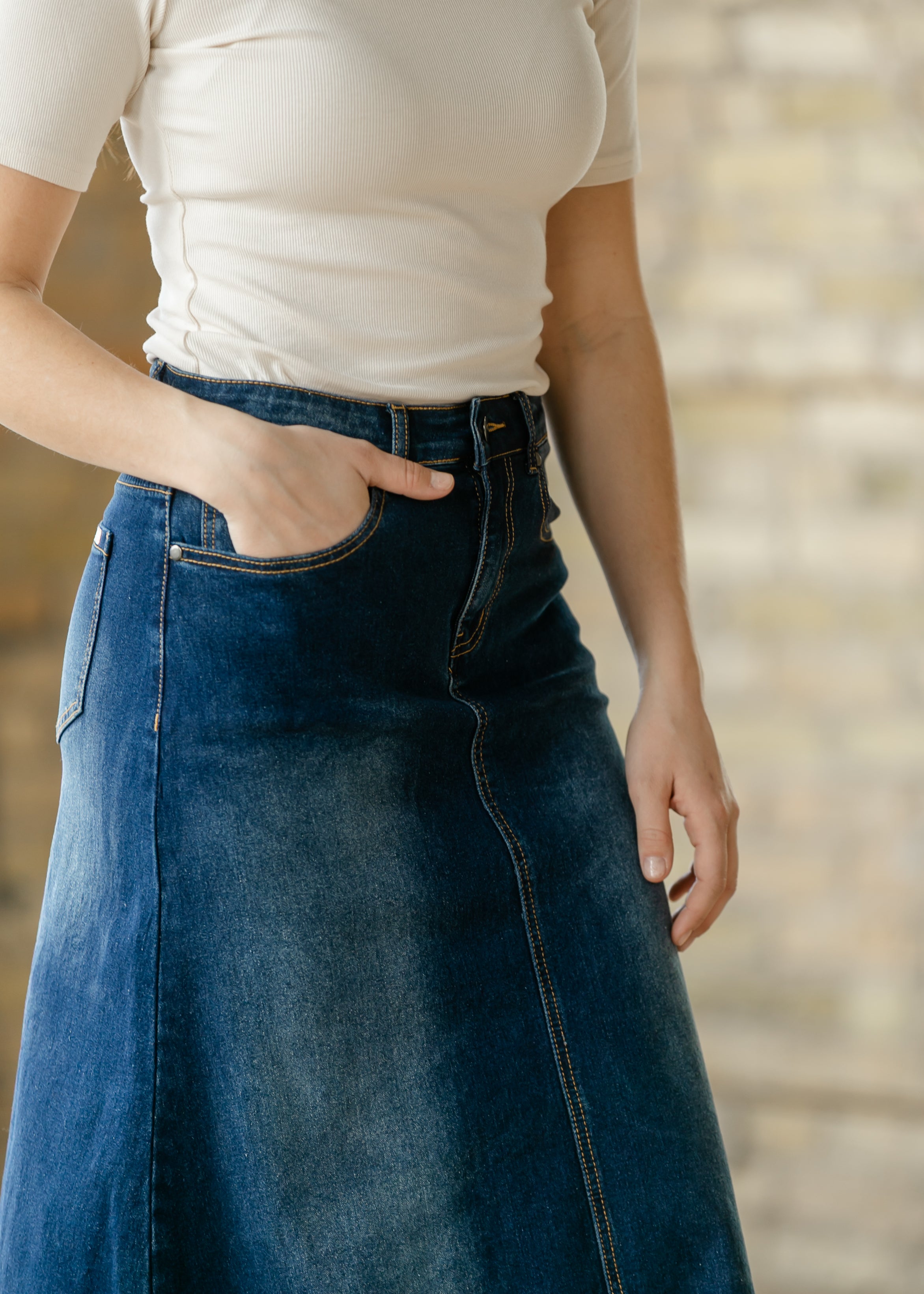 The quality dark wash denim texture and carefully crafted hemline of the Inherit Co. Bethany A-line Long Skirt.