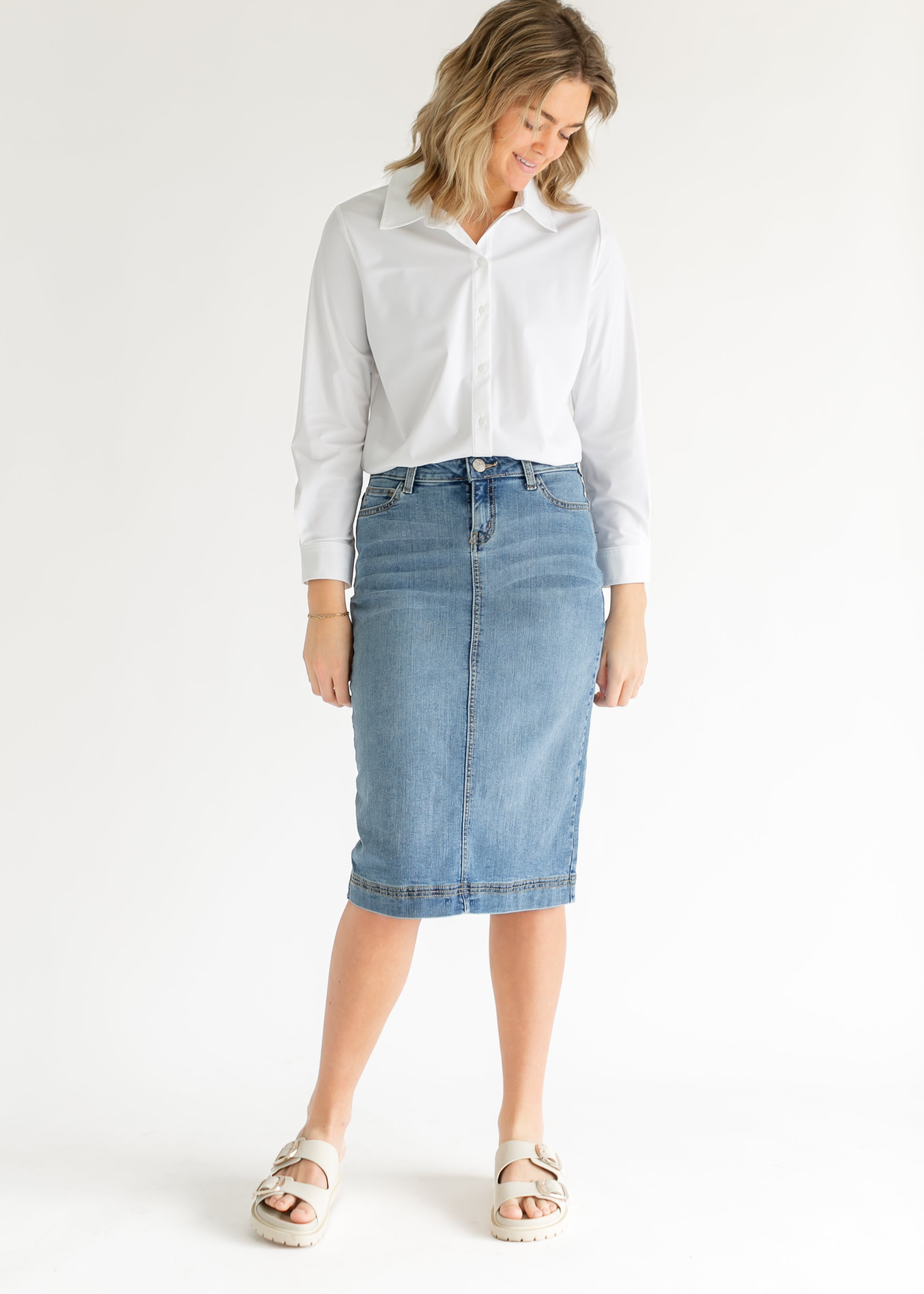 Inherit Co. Bryn Light Wash Denim Midi Skirt styled for a casual look, showing its comfortable midi length and movement.