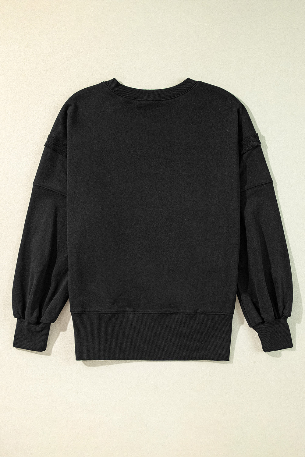 Chic black drop shoulder sweatshirt with exposed seams and side slits