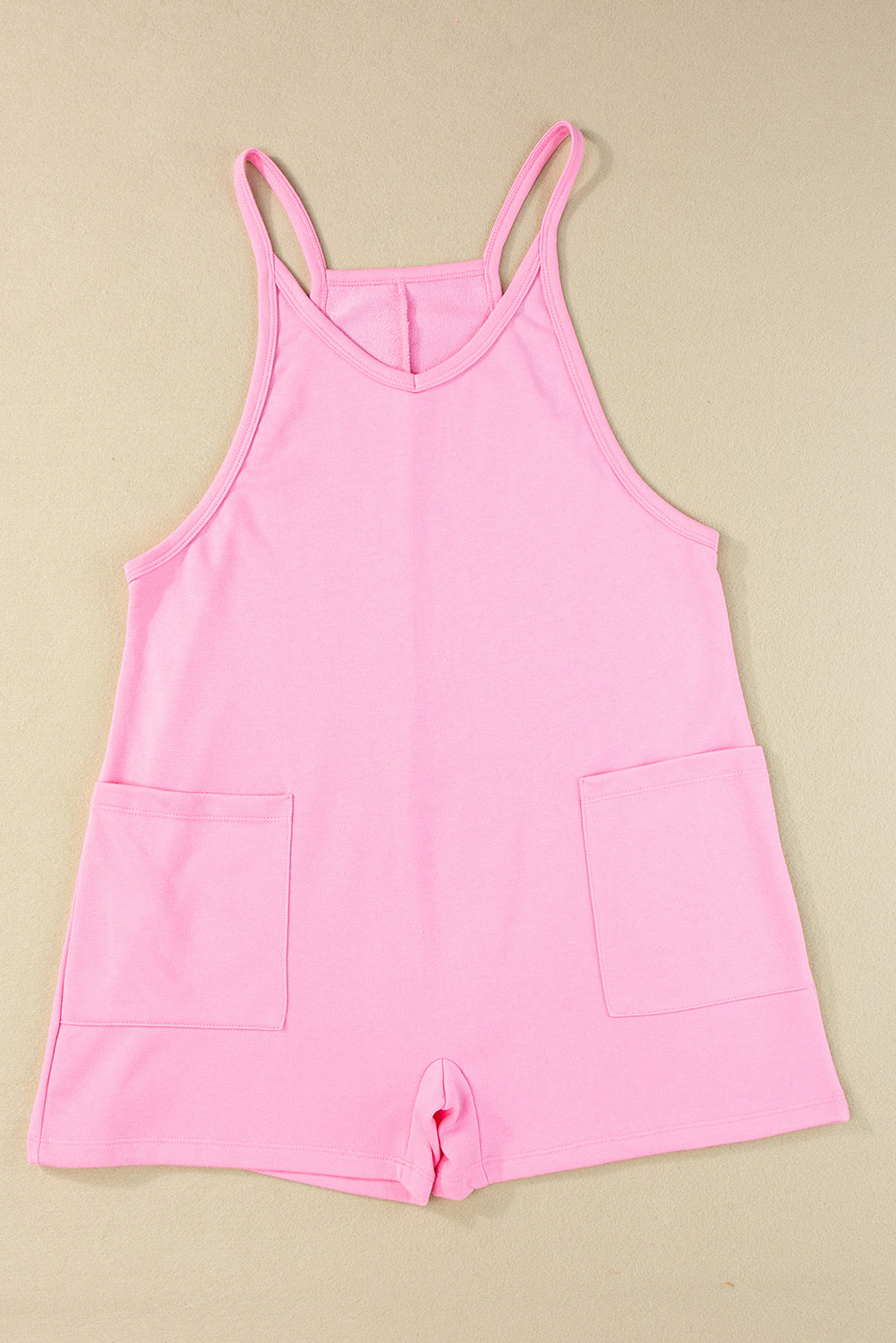 Chic pink sleeveless jersey romper with pockets and v-neck detail