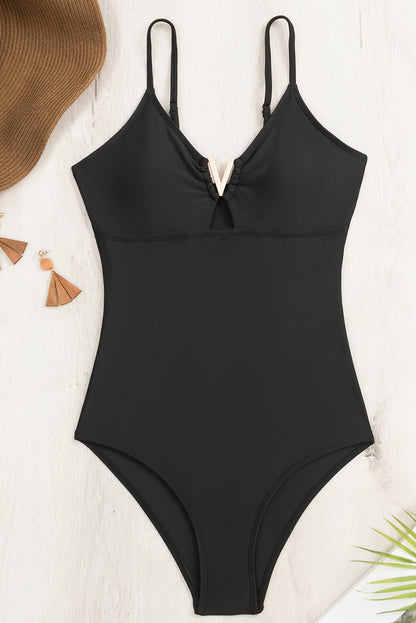 Chic black one-piece swimsuit with metal V detail and adjustable straps