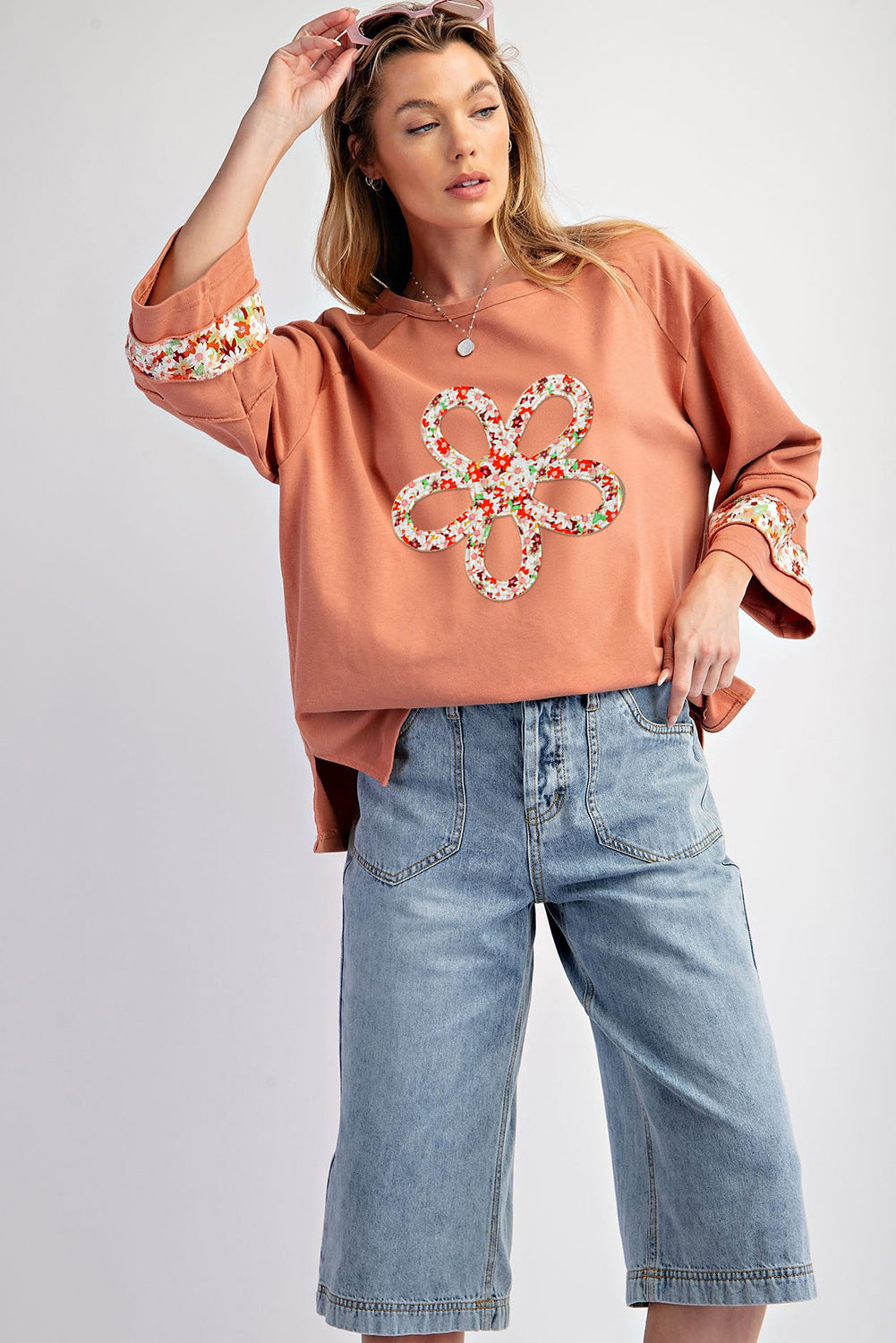 Floral graphic wide-sleeve top with exposed seam detail in grapefruit orange