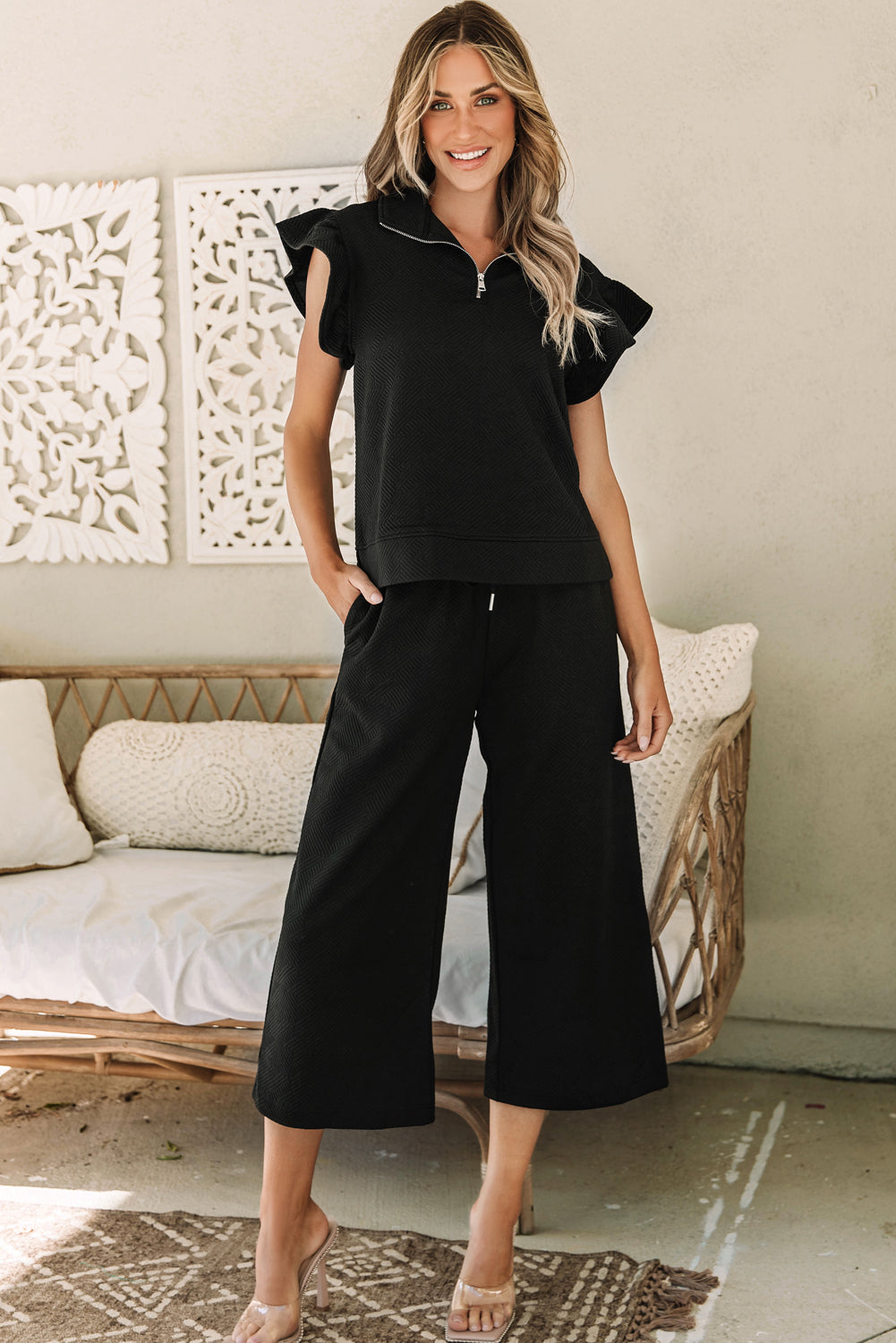 Chic black flutter sleeve top and wide-leg pants ensemble