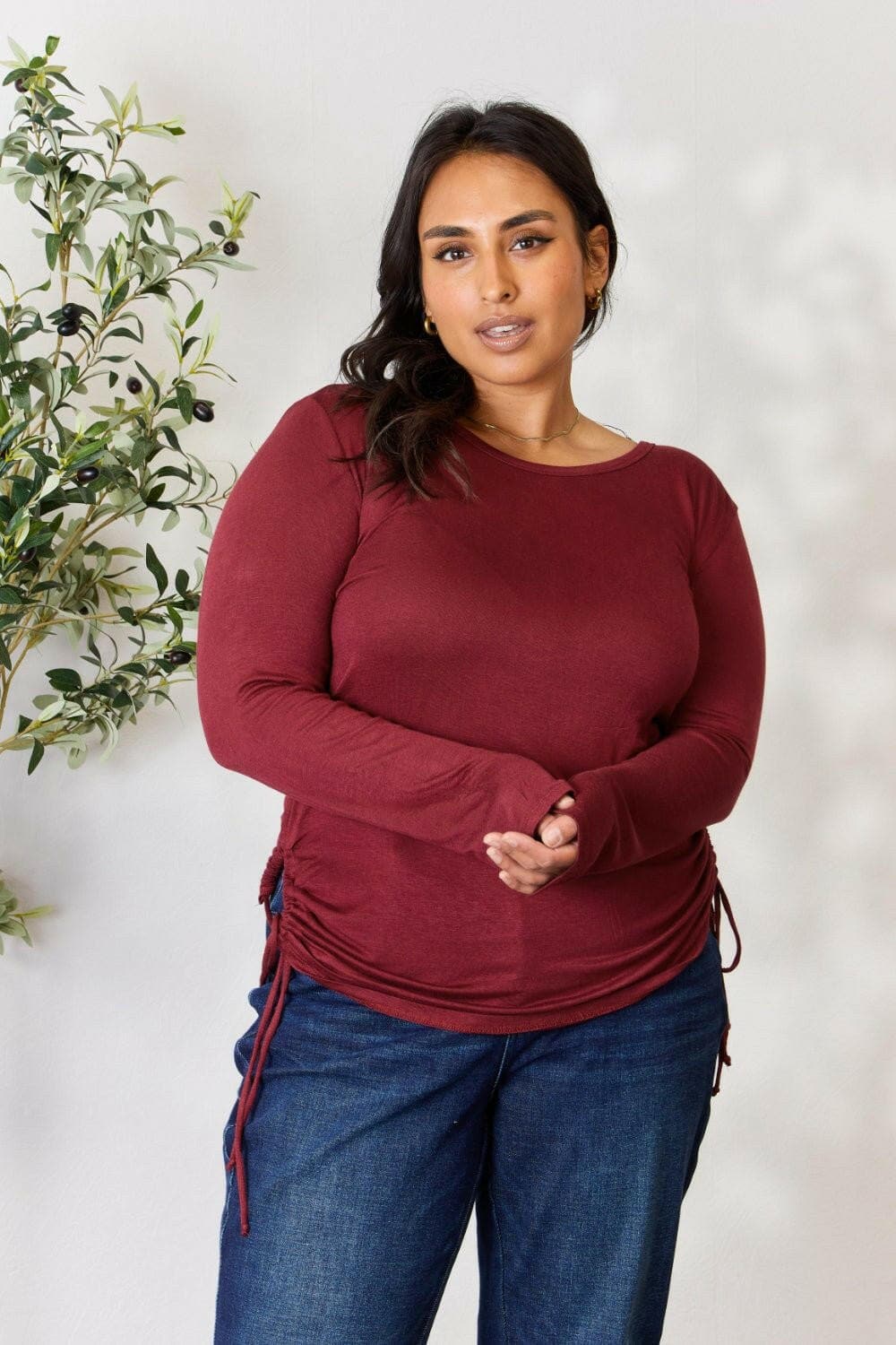 Plus-size model wearing Elegant Comfort Drawstring Top in burgundy with adjustable fit, cozy round neck, and long sleeves.