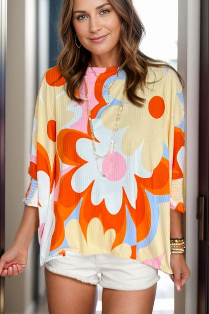 Floral print blouse with sleeves featuring a colorful design, perfect for versatile styling.